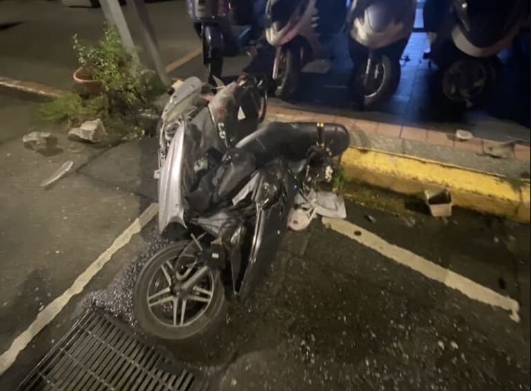 廖男騎車闖紅燈,見警上前追人,還囂張比中指,結果下一秒就自撞路邊鐵柱。(翻攝畫面)