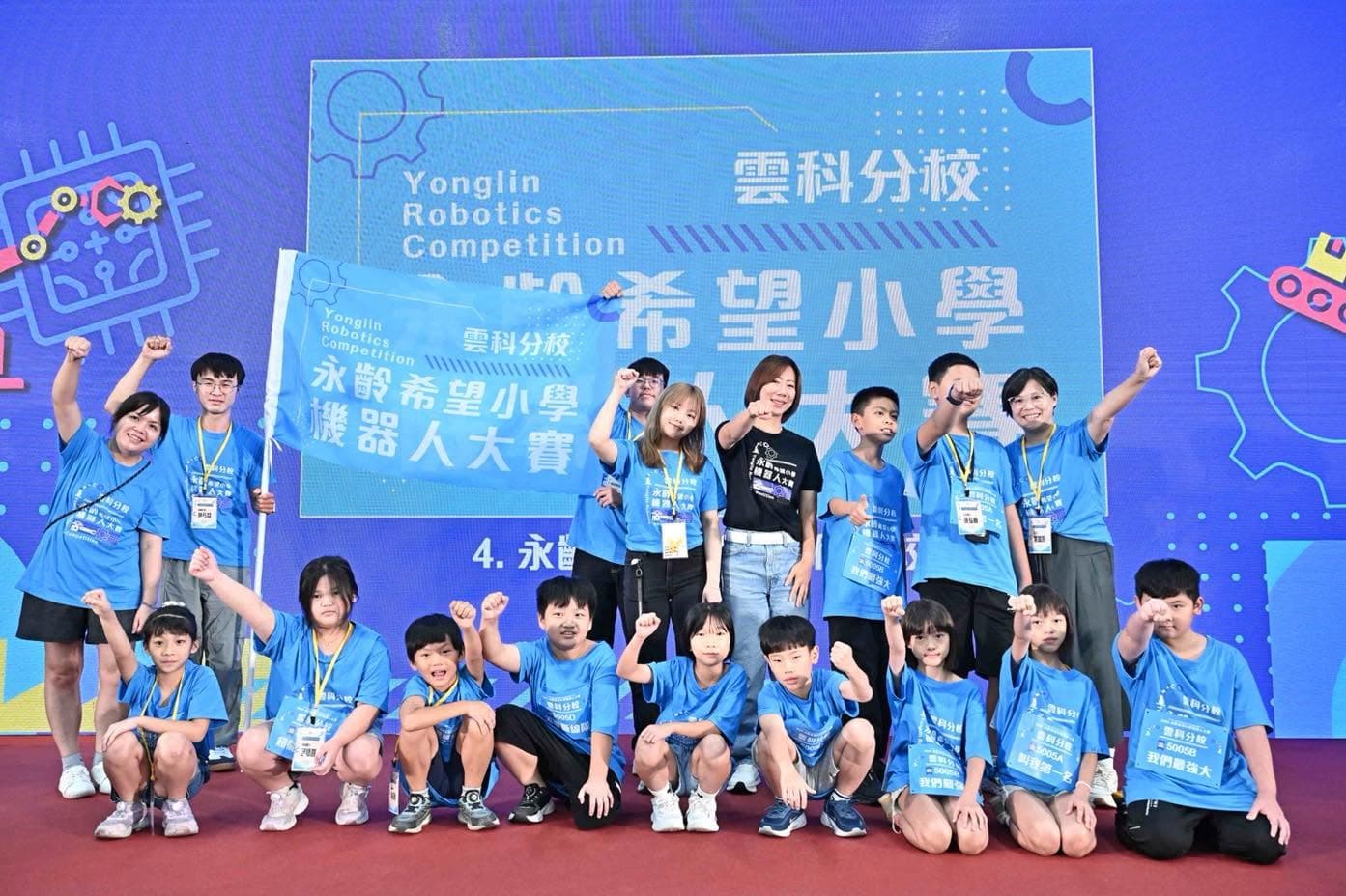 郭曉玲(黑衣者)出席第二屆永齡希望小學機器人大賽,與參賽學童合影。(永齡基金會提供)