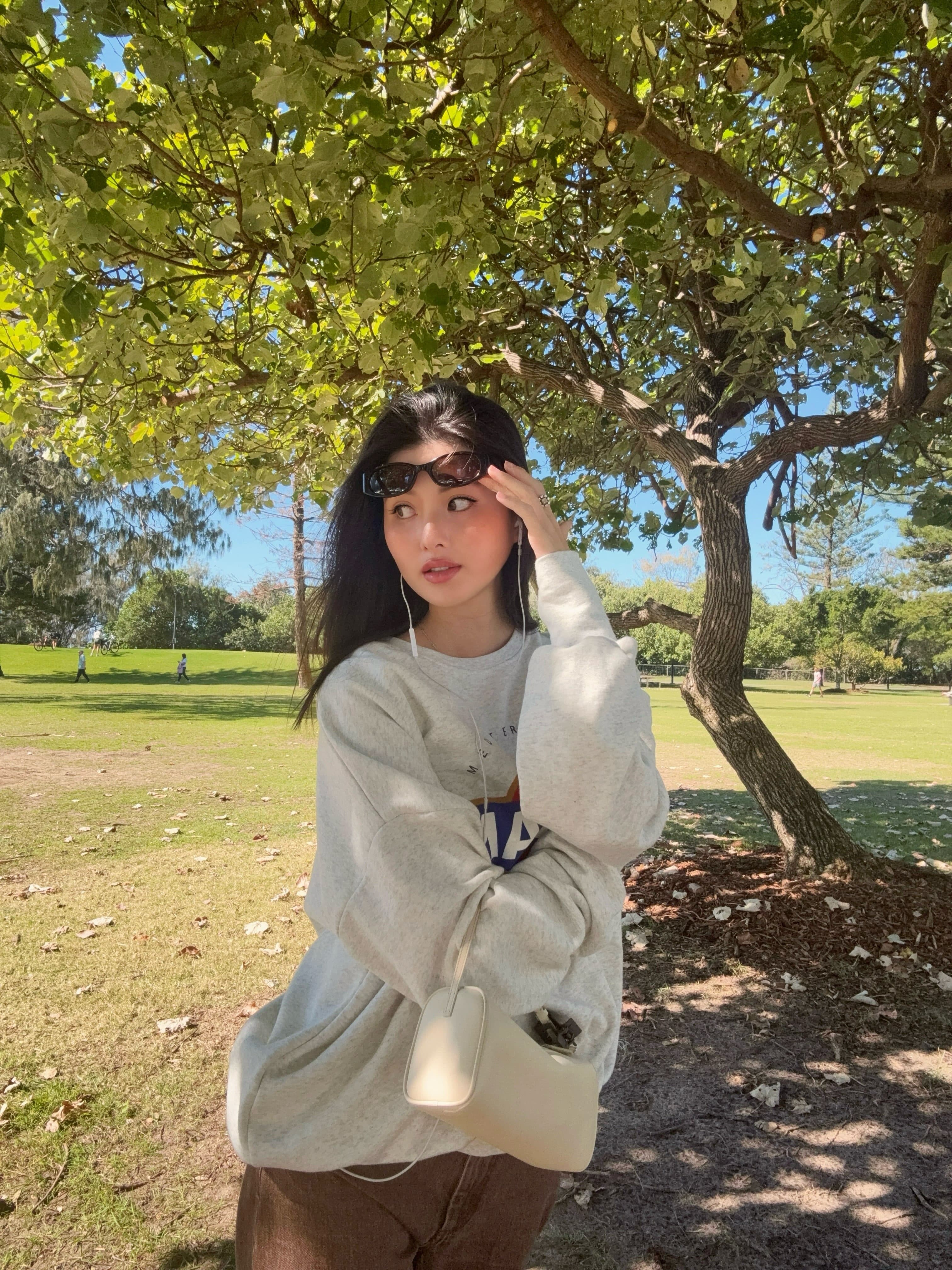 廖思惟換上休閒大學T與寬鬆長褲,肩背白色The Row 90's Bag。(翻攝trinityliao IG)
