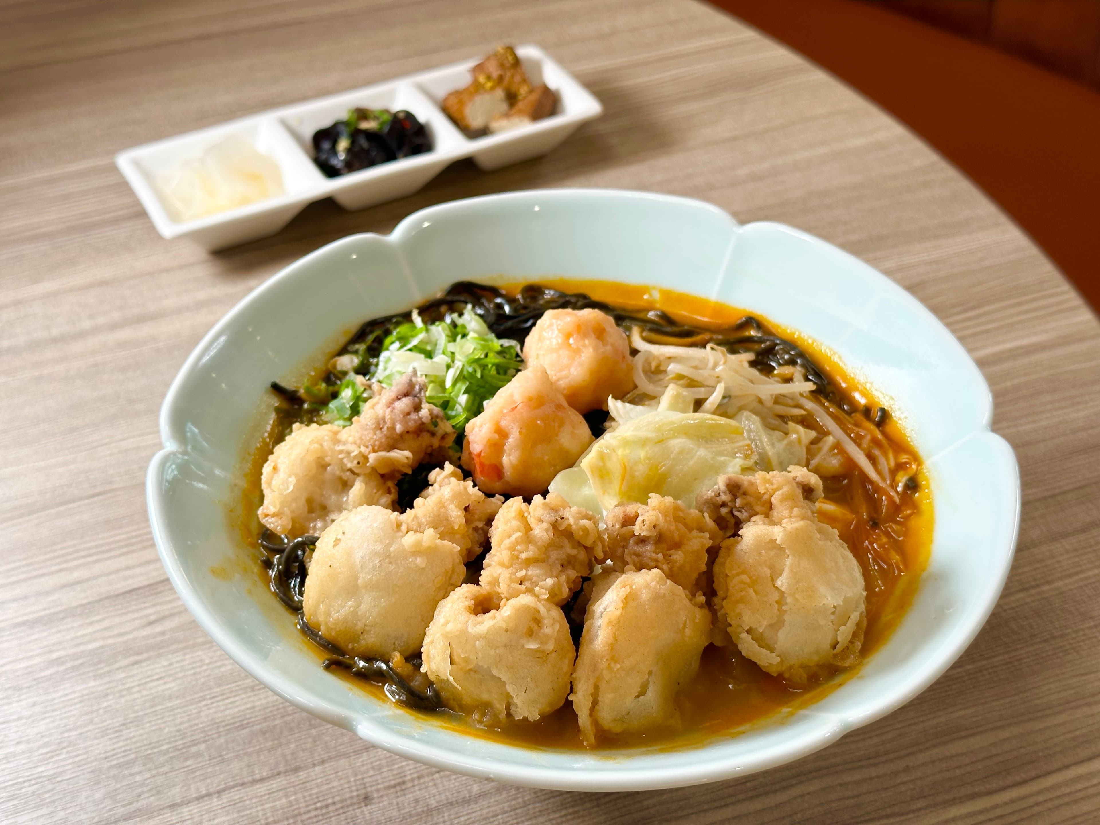 「花黑pun豪華海鮮拉麵」配料有酥脆彈口的炸小花枝，軟嫩的蝦滑，墨魚細麵滑Q不爛，湯頭蝦味濃厚。（368元／碗）