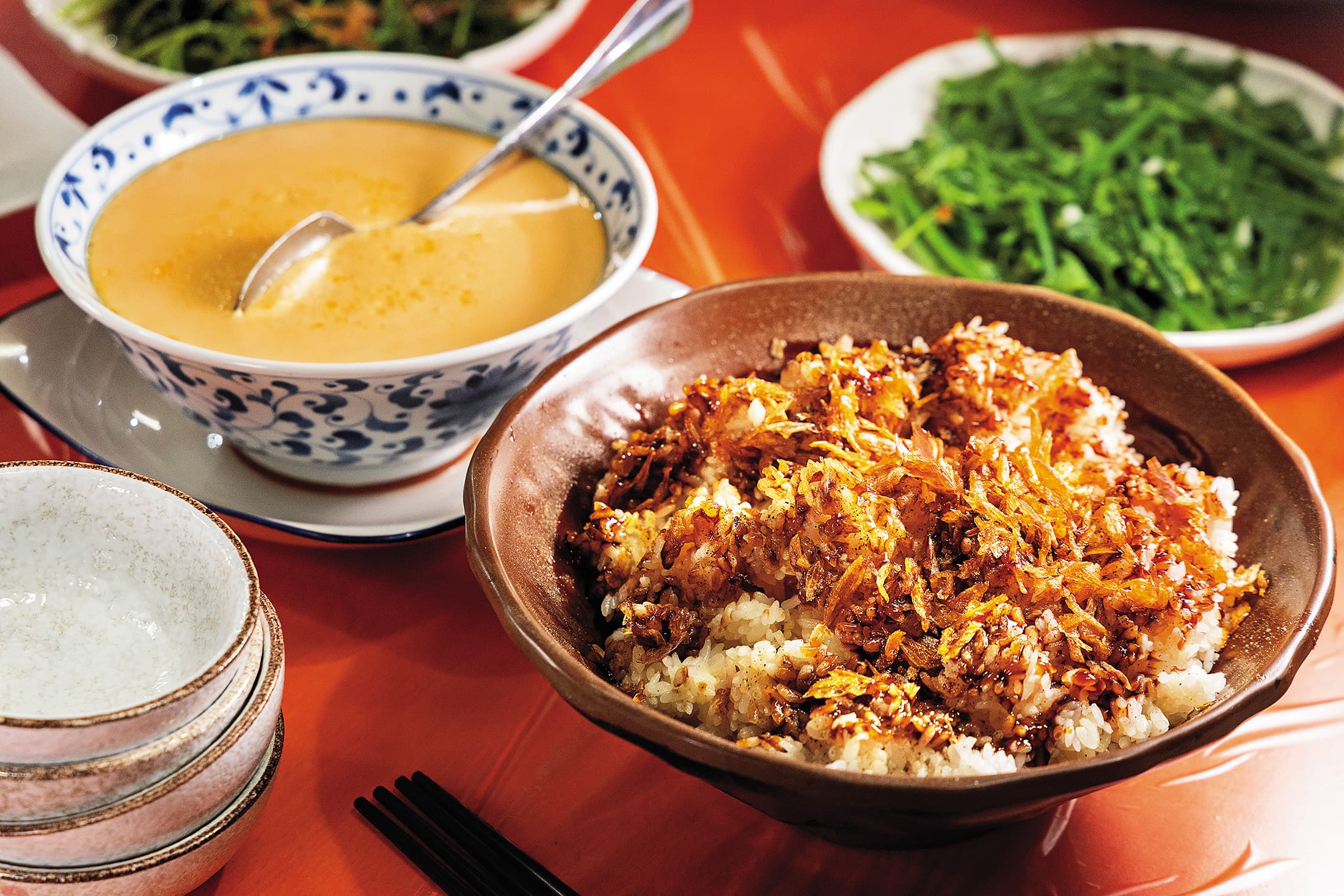 淋上雞油與油蔥酥的「雞油飯」（前，150元／鍋）與「蒸蛋」（左後，250元／份）都是餐廳的招牌菜。
