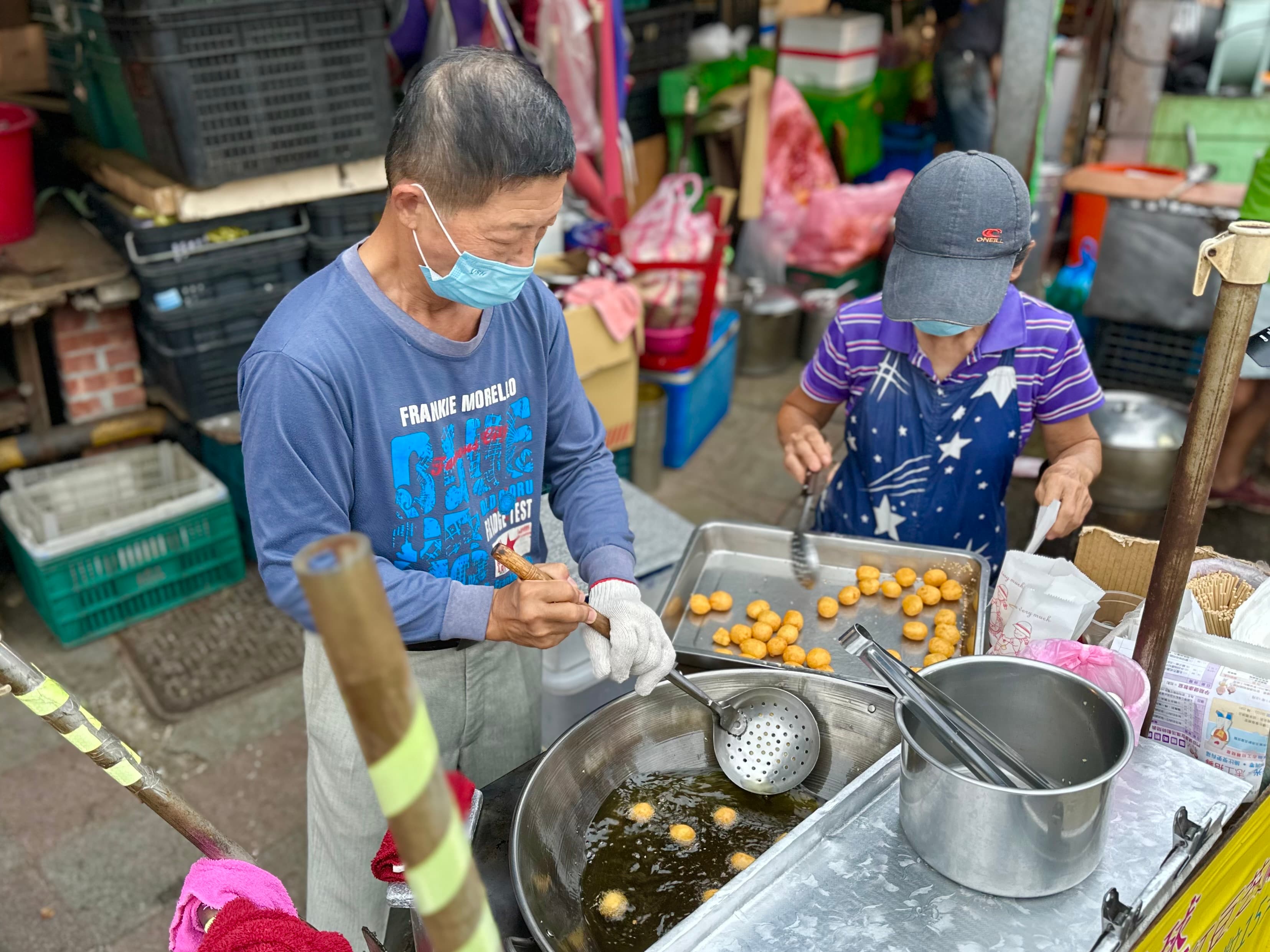 老闆會用漏勺，一粒一粒碾壓地瓜球，不只瀝掉多餘油分，也壓出麵糰的筋性。