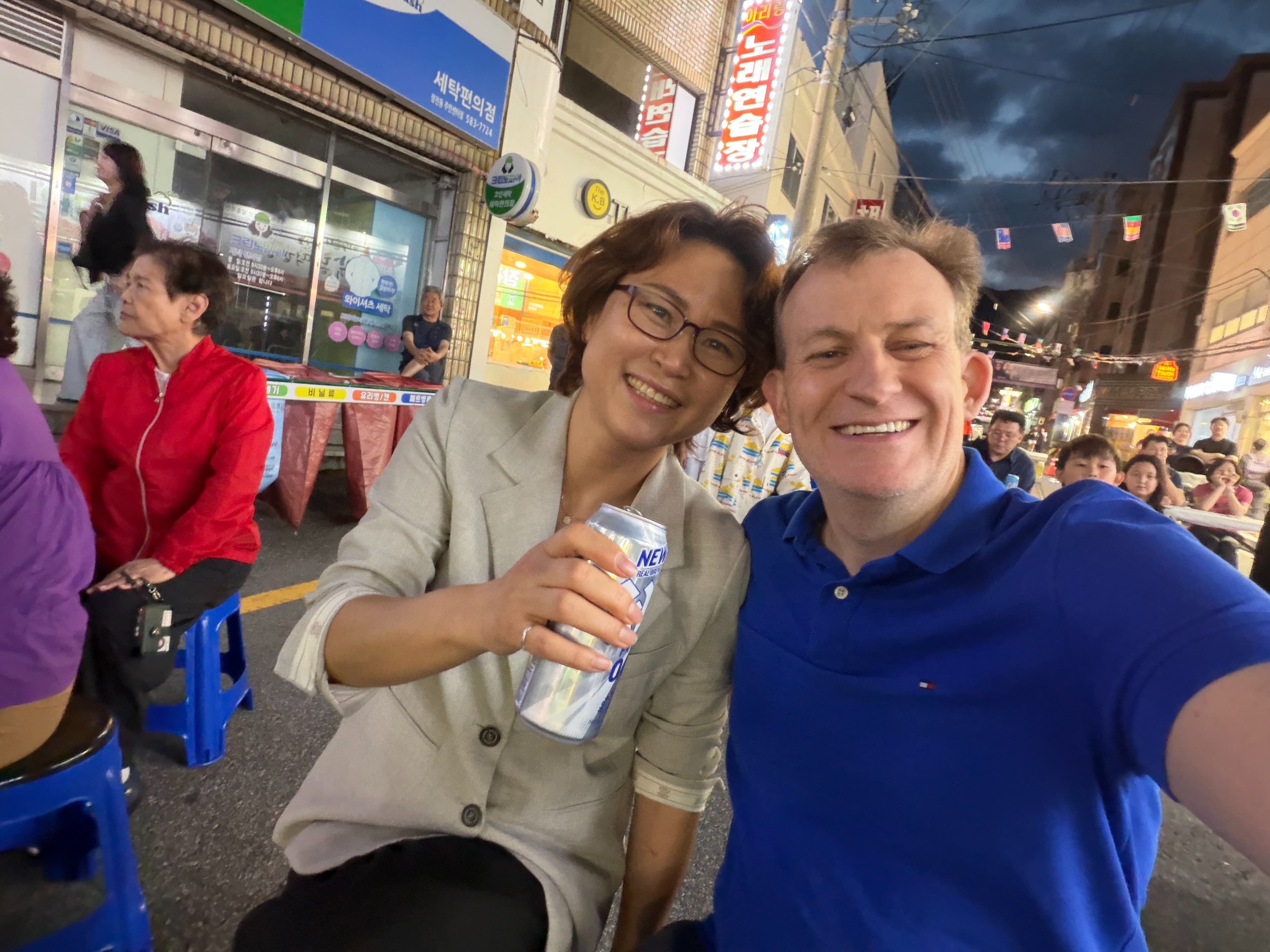 凱利（右）和妻子金正雅（左）參加街頭慶典。（翻攝X@Robert_E_Kelly）