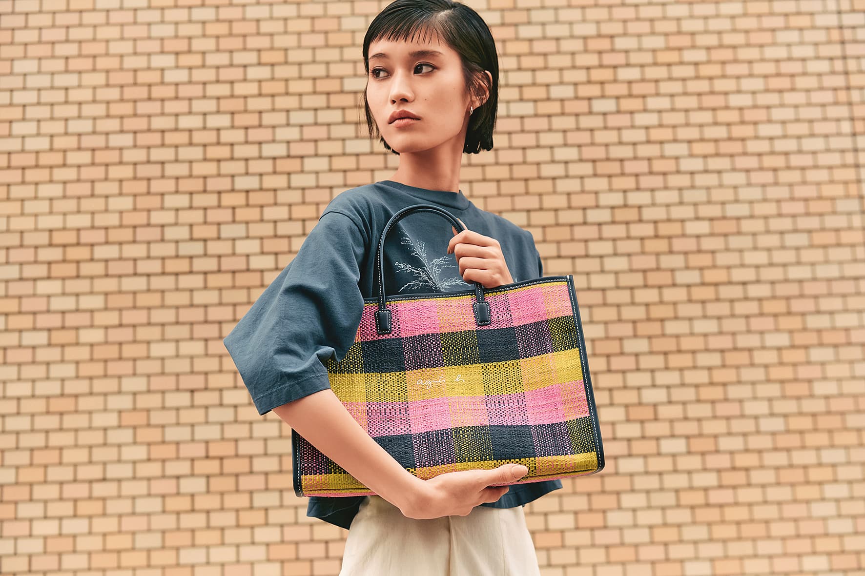 agnès b.以「City to beach」為主題推出VOYAGE系列夏日包款。拉菲草手提包中型NT$7,280。(agnès b.提供)