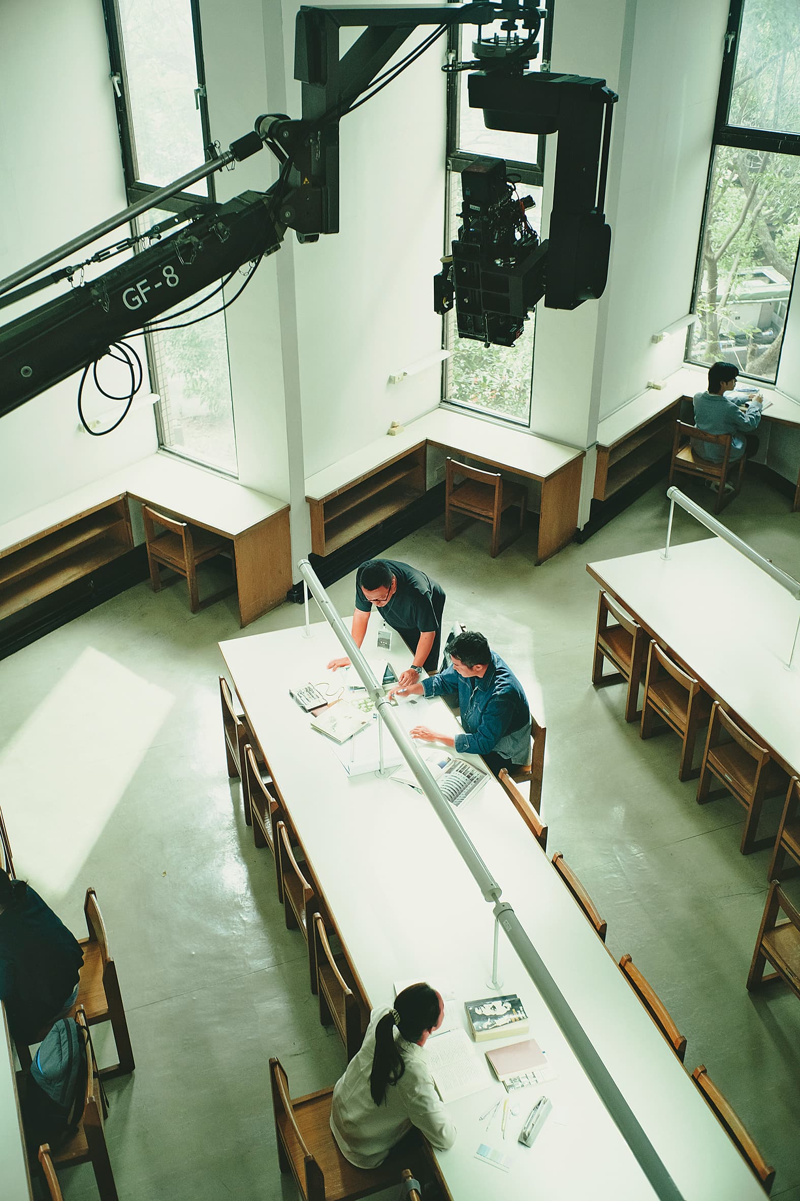 電影第一場戲在政大圖書館拍攝，導演沈可尚（上）與演員張孝全（中）、林依晨（下）溝通討論。（風起娛樂提供）