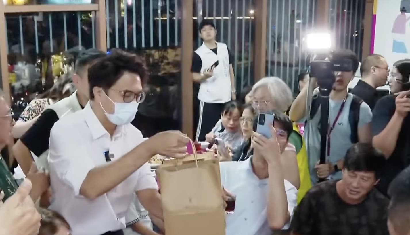 徐男這次現身南門市場，送上自己親手烘焙的咖啡豆給沈伯洋當禮物。（鏡新聞）