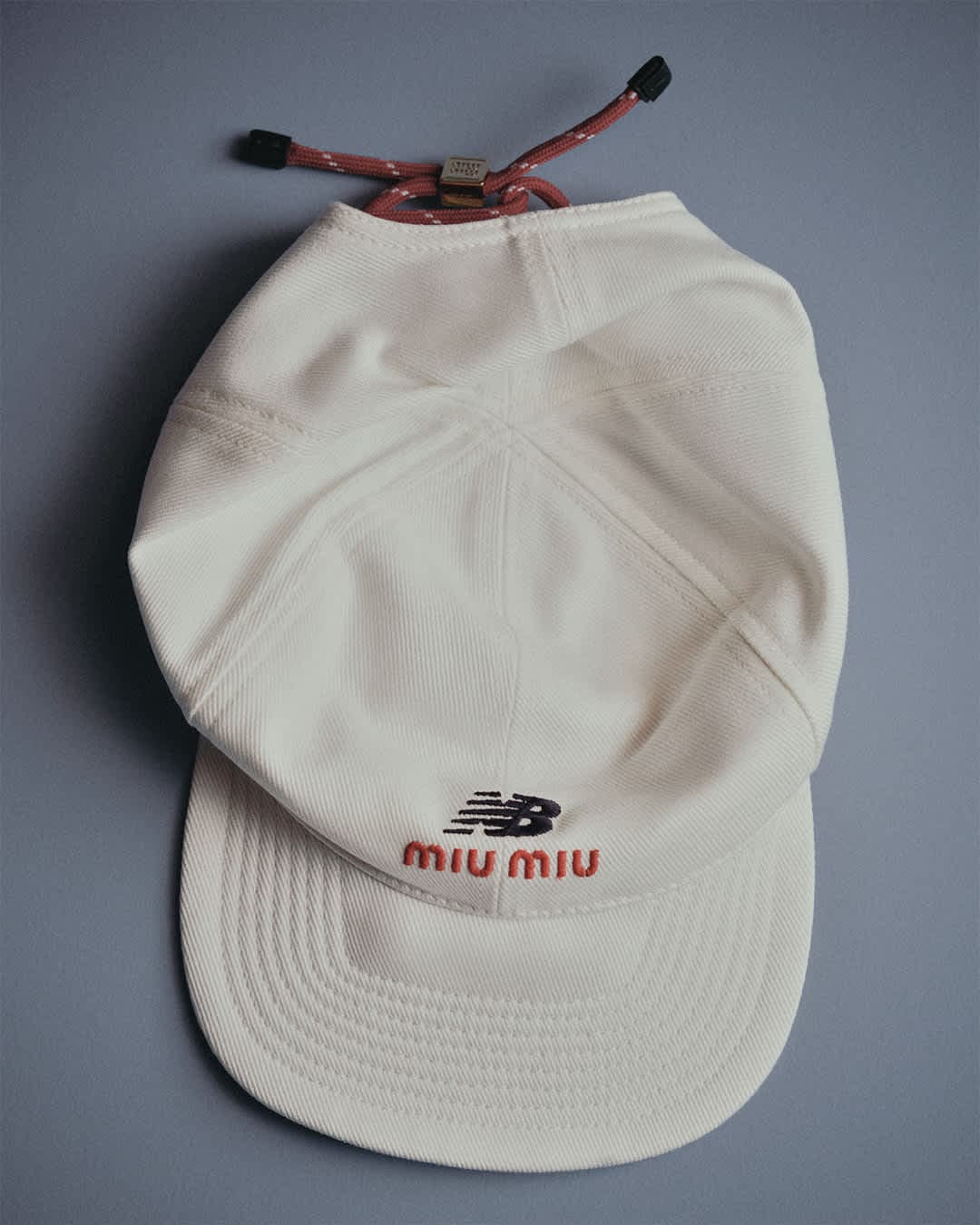 帽款飾有海軍藍與紅色的New Balance X Miu Miu 聯名標誌。(Miu Miu提供)