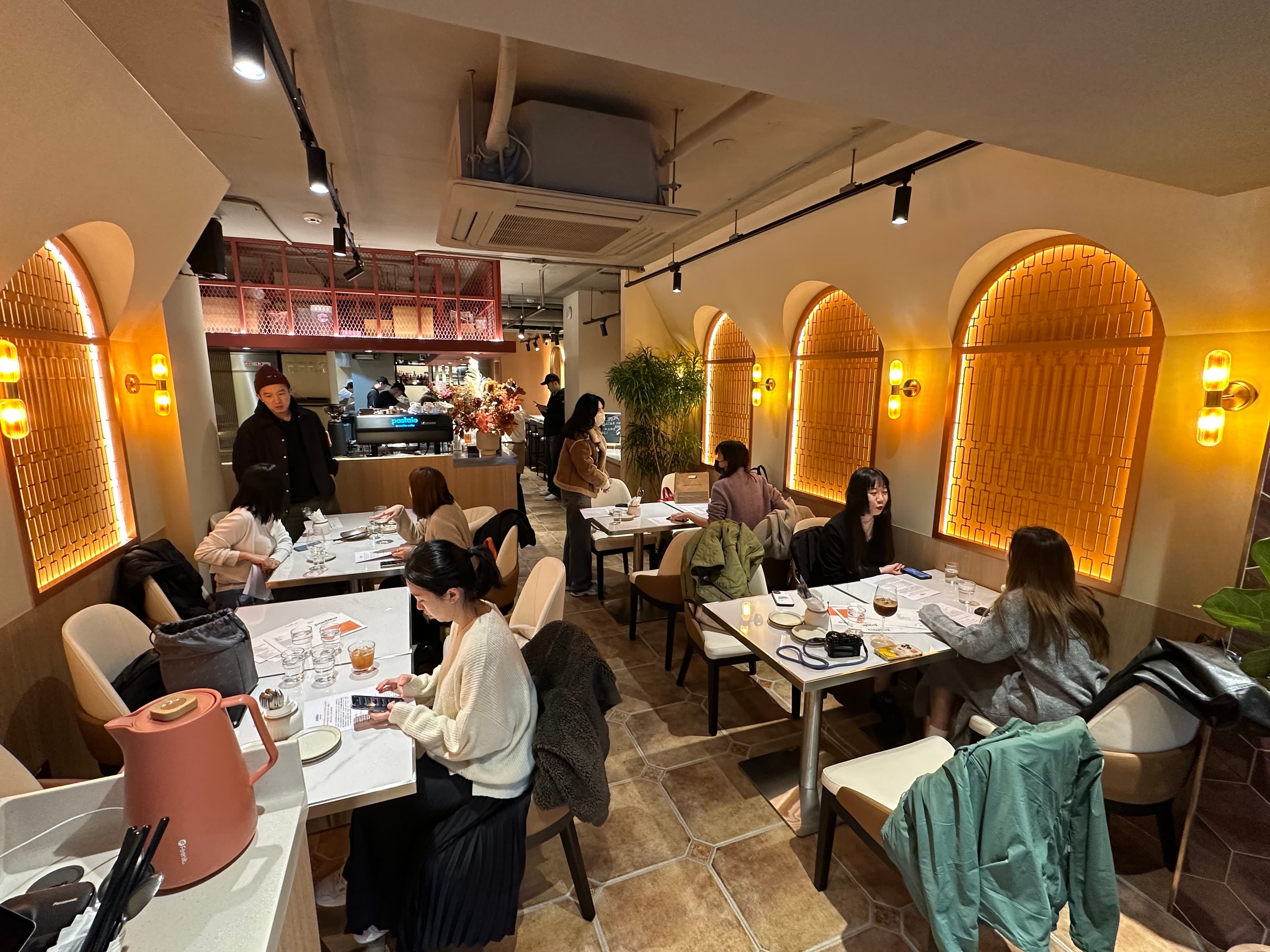 店內以圓拱元素，搭配大理石桌和植栽，營造簡約時尚風。