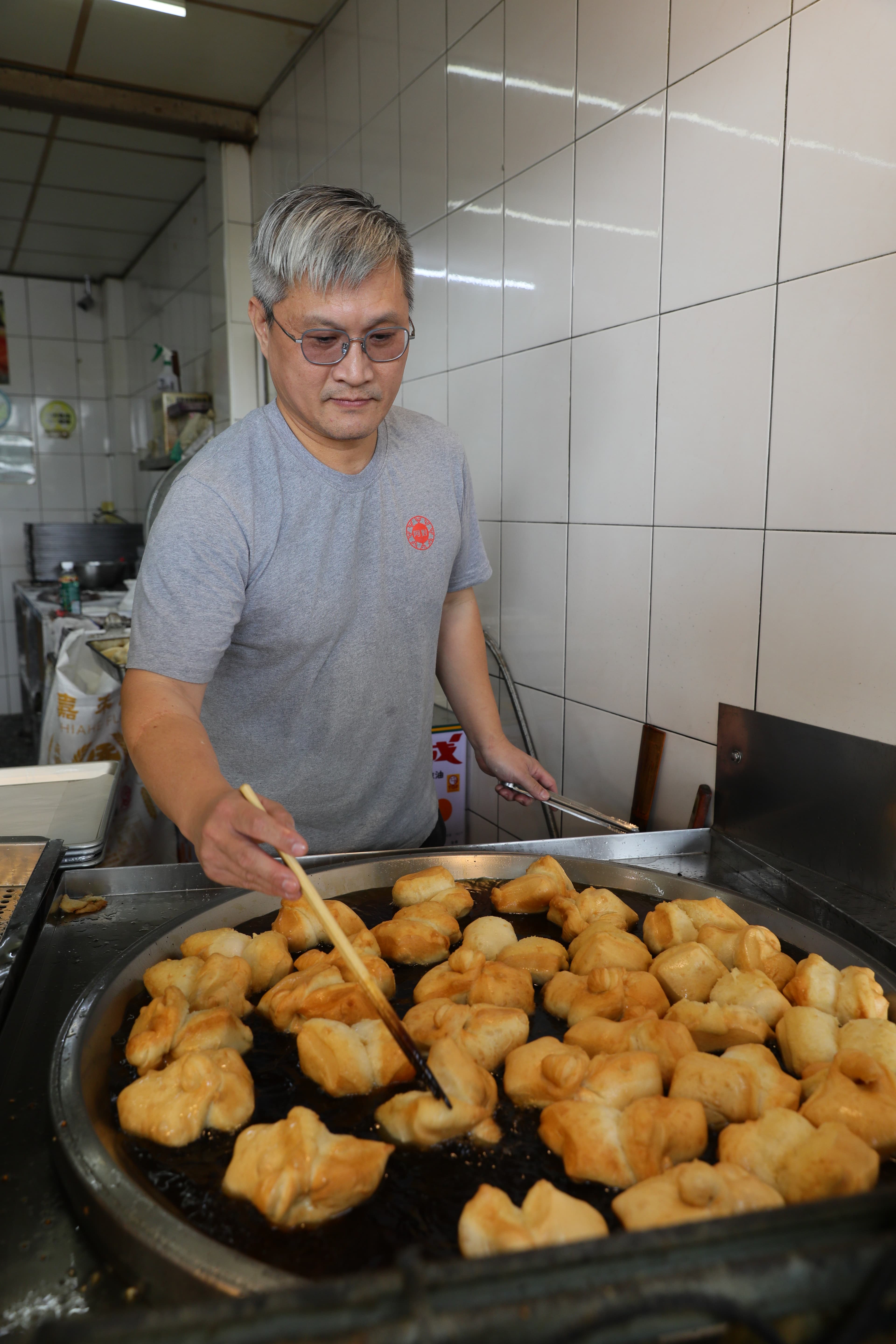 老闆熟練的翻動鍋中的雙胞胎，油溫需超過攝氏170度才能將外皮炸得又香又酥。
