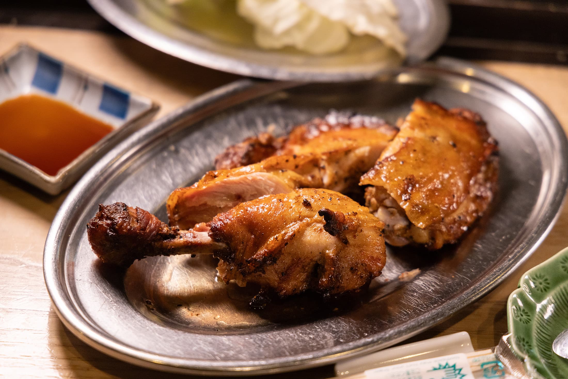 招牌「帶骨烤雞腿」以獨門醬料醃漬，外皮金黃焦脆，肉裡柔嫩多汁。（團餐菜色，4,000日圓／人，約NT$880）