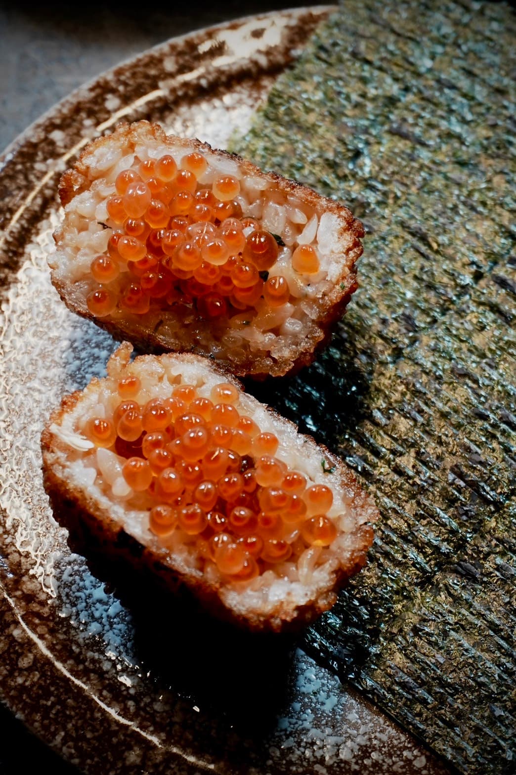 外層醬烤到如餅乾般脆口，內餡包覆滿滿鮭魚卵的「鮭魚卵炸飯糰」。 （加購價99元／人）