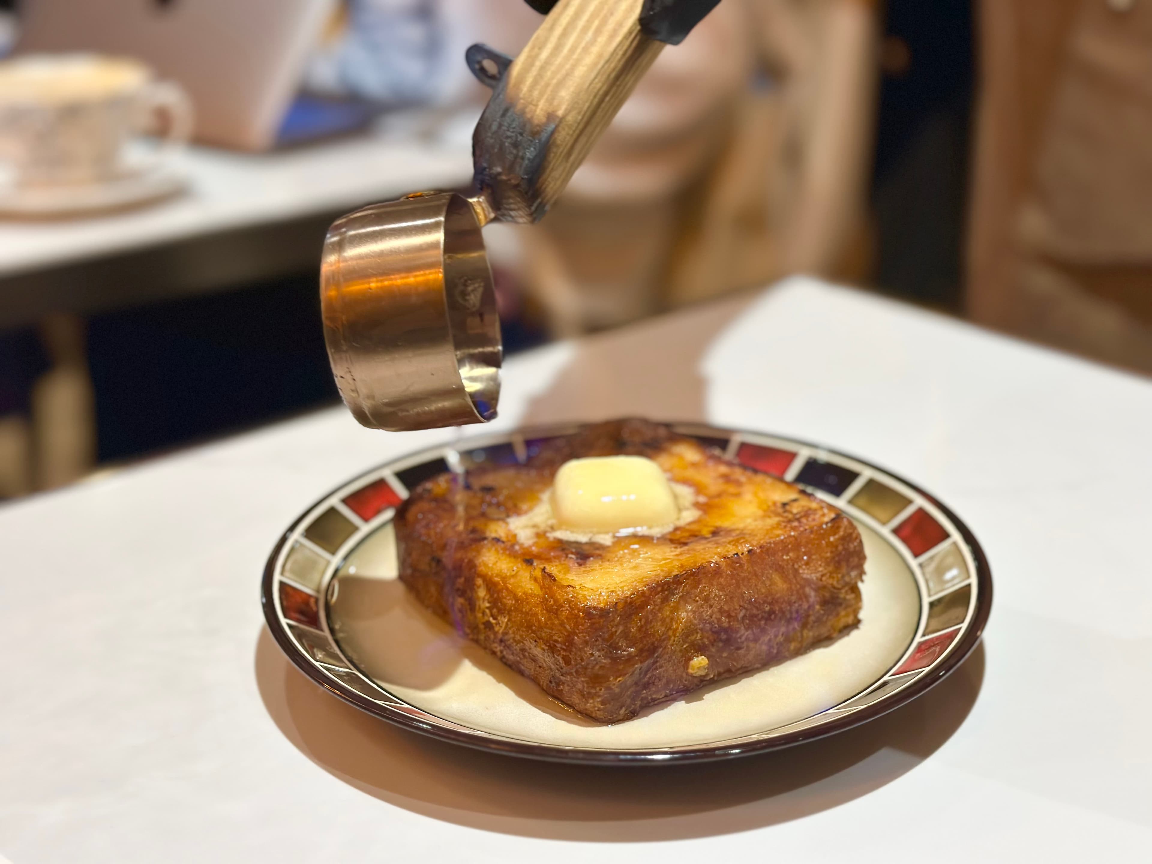 「火焰橙香蜂蜜」會在桌邊淋甜酒再點火，讓法式布蕾吐司吃來外脆內鬆，有淡淡酒香。（360元／份）