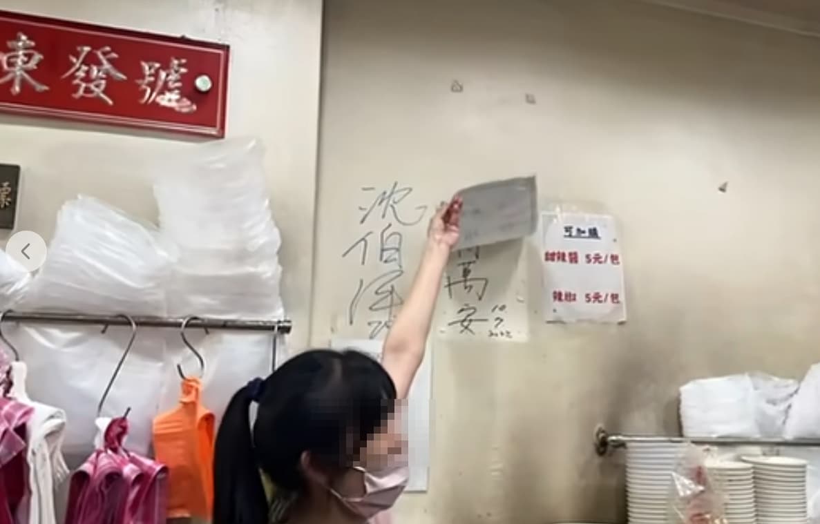 沈伯洋在「東發號」簽名後,業者掀開一旁「蓋住」許久的蔣萬安簽名。(翻攝自周軒臉書)