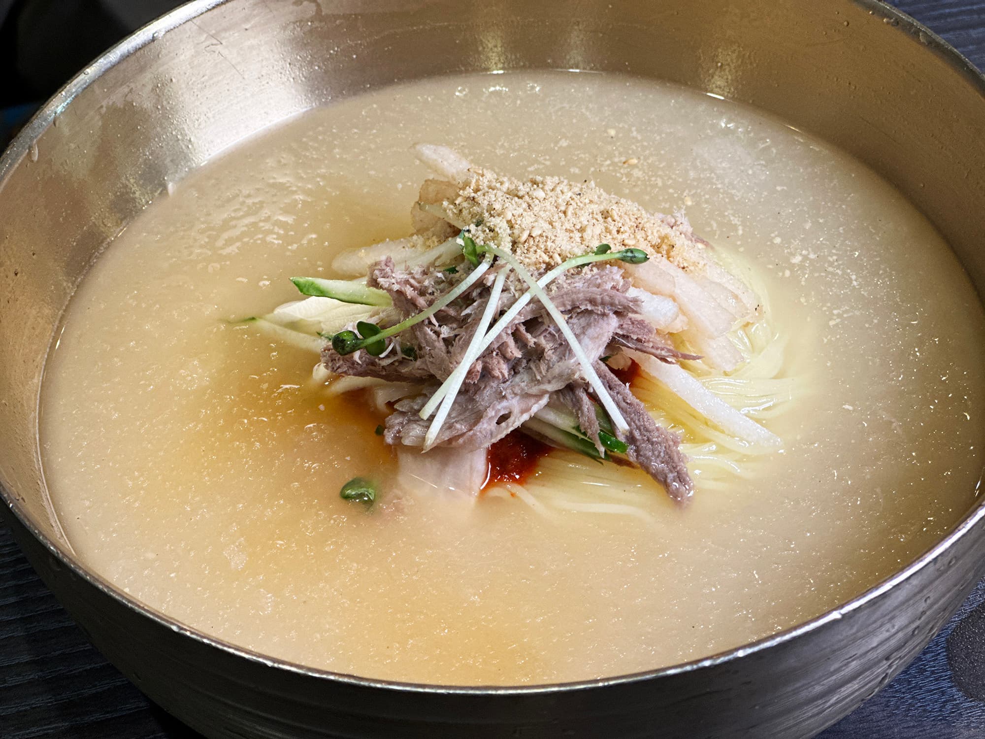 以大骨熬煮湯底的「水麥麵」,在吃之前建議先品嘗原味湯汁。(單點9,000韓元/份,約NT$225,搭配煎豬排6,000元/份,約NT$150)