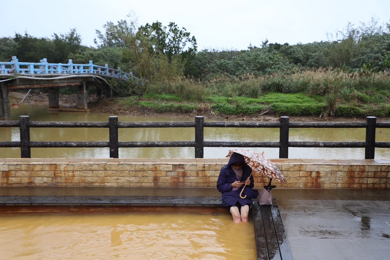 即使天空飄著毛毛細雨,遊客依然甘願撐傘享受泡腳池的暖熱湯泉。