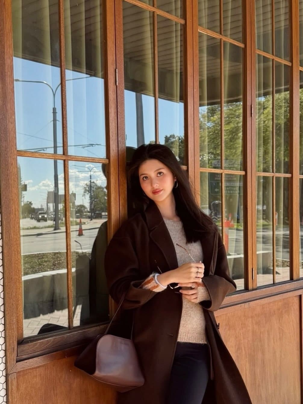廖思惟身穿棕色長版大衣,手拎The Row Peggy Clutch,簡約造型展現低調質感。(翻攝trinityliao IG)