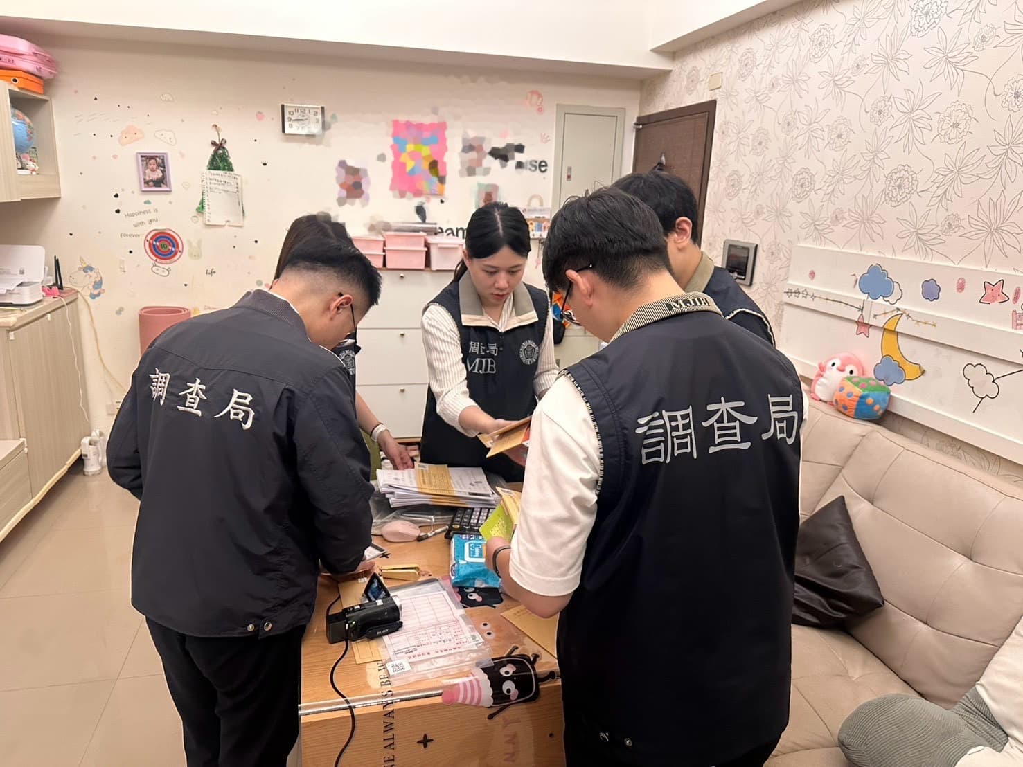 調查局在搜索現場清點地下通匯業者帳冊資料。(調查局提供)